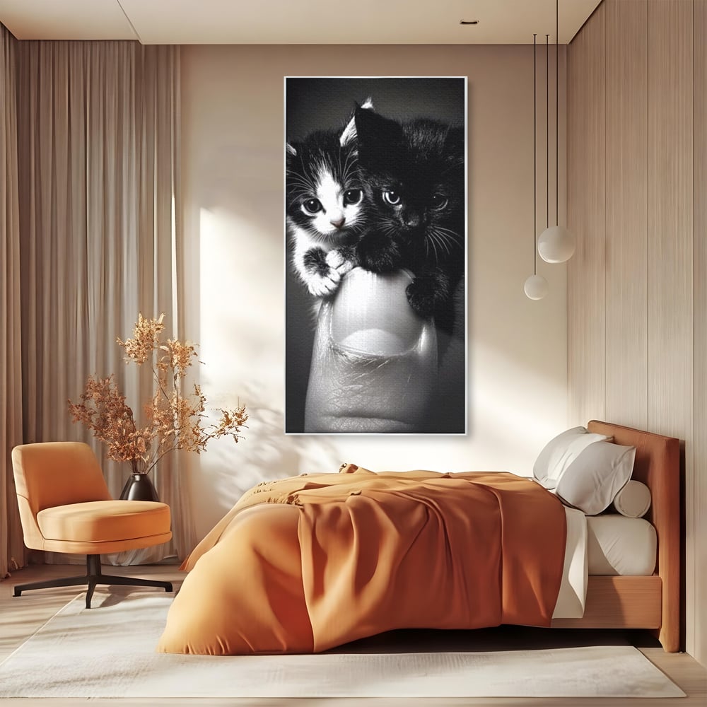 Tablou canvas cu tablou canvas cu doi pisoi mici agatati de un deget, in rama de aluminiu argintiu, pe perete intr-un dormitor